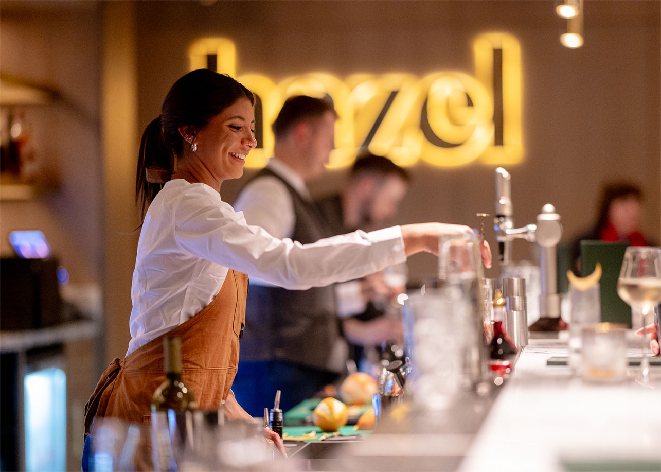 Smiling barmaid mixing a cocktail