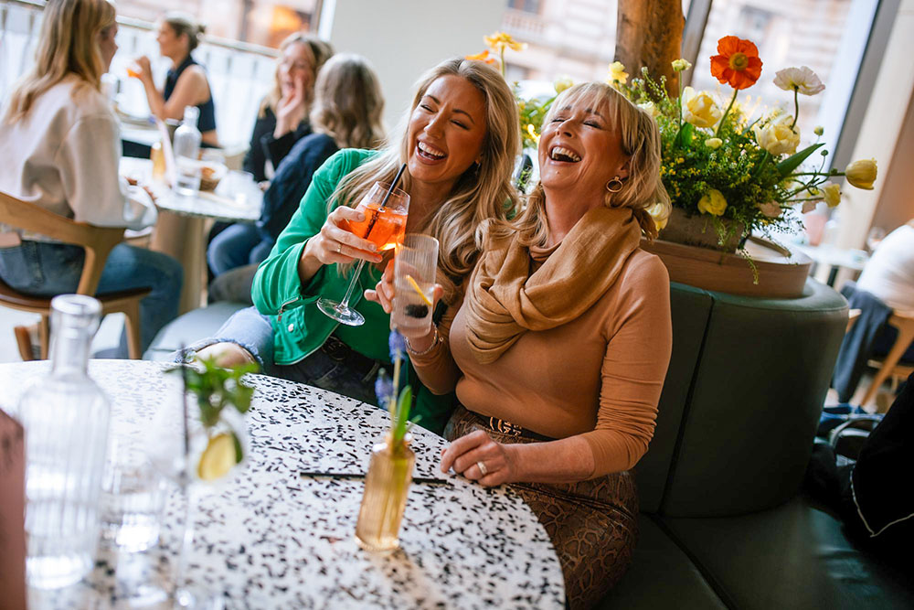 Two Ladies Laughing With Cocktails
