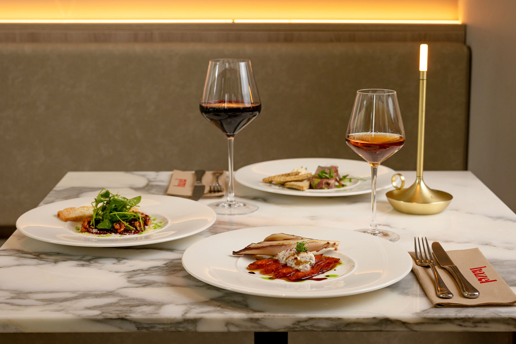 Three plates of delicious food and wine